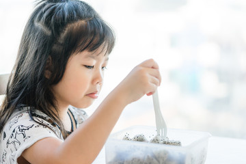 Wall Mural - Little asian girl don't want to eat dragon fruit she hate every fruits.bored face bored food.5 years old girl does not want to eat her healthy foods