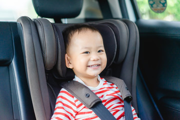 Wall Mural - Transport, safety, childhood road trip and people concept - Happy baby boy sitting in baby car seat or booster seat, Child in auto baby seat in car, Asian boy in summer vacation to travel with family.