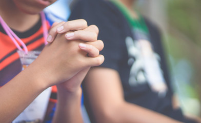 Wall Mural - Teenager boy praying at church in the morning.teenager boy hand with faith praying,Hands folded in prayer on a Holy Bible in church concept for faith, spirituality and religion