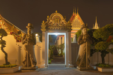 Wat Phra Chetuphon or Wat Pho, a Buddhist temple illuminated at night in Bangkok City, Thailand. Thai architecture buildings background in travel trip and holidays vacation concept.