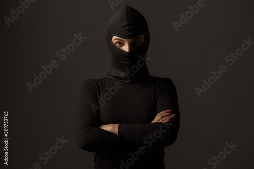 Fotomural Unknown woman in a black mask on a gray background