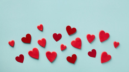 Valentine day card or banner. Many red hearts on blue background top view. Flat lay.