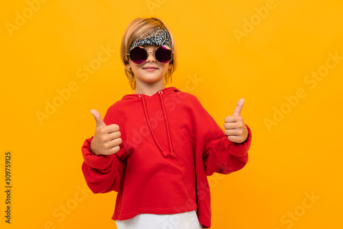 Cuadros en Lienzo attractive blond boy with a bandana on his head in a red sweater and glasses sho
