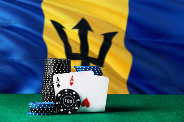 Barbados casino theme. Two ace in poker game, cards and black chips on green table with national flag background. Gambling and betting.