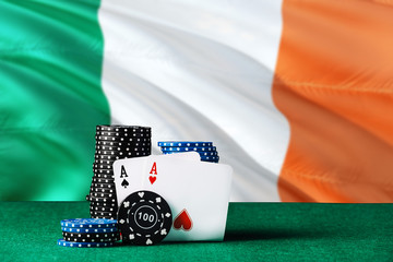 Ireland casino theme. Two ace in poker game, cards and black chips on green table with national flag background. Gambling and betting.