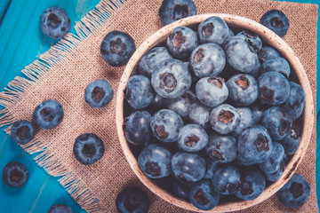 Wall Mural - Raw fresh huckleberry in a bowl. Wooden background.