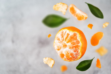 Wall Mural - Flying tangerine fruit with slices, peel and leaves