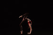 © New Africa - Young woman performing acrobatic element on stage indoors