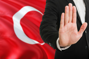 Wall Mural - Turkey rejection concept. Elegant businessman is showing stop sign with hand on national flag background.