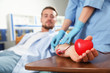 © New Africa - Young man making blood donation in hospital, focus on hand