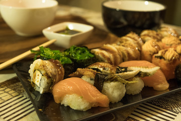 Many different sushi rolls on a plate close up. Serving on the table in the restaurant