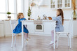 © Margo Basarab - two children sitting on the kitchen table and eating candies. Mother with daughter and toddler son having breakfast at home. Happy lifestyle family moments.