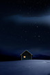 Weihnachtlich beleuchtete Hütte in Kalter Winternacht mit Sternenhimmel