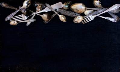 Wall Mural - Vintage cutlery - spoons, forks and knives on an old wooden background.