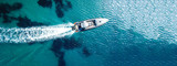 Aerial drone ultra wide top down photo of luxury rigid inflatable speed boat cruising in high speed in Aegean deep blue sea, Greece