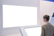 © zyabich - White screen, mock up, future, copyspace, template, isolated, technology concept. Woman looking at blank digital interactive white display wall at exhibition or museum with futuristic scifi interior