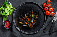 Mussels In Tomato Sauce Decorated With Parsley And Cherry Tomatoes. Black Background. Top View