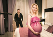 © YouraPechkin - Beautiful young couple charming husband touches the belly of his beautiful pregnant wife standing in a beautiful bedroom with a stylish interior. Concept Waiting for the Firstborn