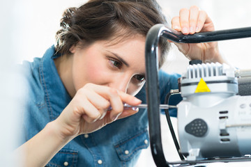 woman fixing machine in office