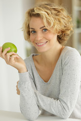 woman with apple smiling at the camera