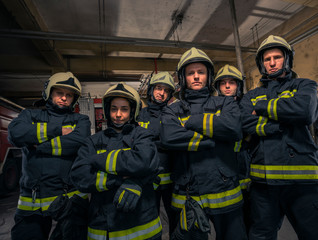 Group of firefighters standing confident with arms crossed. Firemen ready for emergency service.