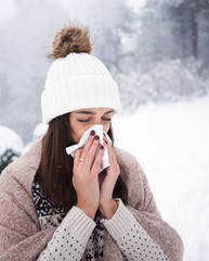 Woman blowing her nose at winter day