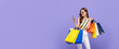 Beautiful Asian woman carrying colorful bags shopping online with mobile phone