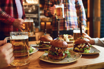 Burger with beer on the table in a bar pub.