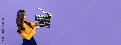 Cuadros en Lienzo Young beautiful Asian girl holding movie clapperboard