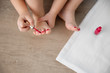 © Lisa Tichané - Close up of little girl applying nail polish to toenails