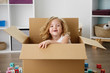 © Lisa Tichané - Portrait of smiling little girl sitting in cardboard box at home