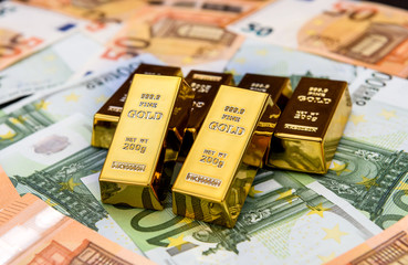 Euro banknotes and gold ingots close up