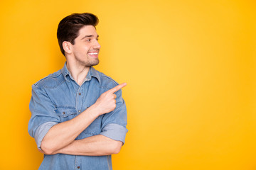 Portrait of nice attractive content cheerful cheery guy pointing forefinger aside advert copy empty black place space follow subscribe isolated over bright vivid shine vibrant yellow color background