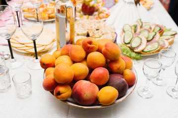 Wall Mural - Fresh fruit peaches, apricots and plums on a plate on the holiday table