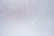 Ice and frost on a window pane in winter. Weather forecast: cold, frost, cooling. Abstract light blank background or wallpaper. Harsh season. Low contrast