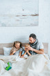 © LIGHTFIELD STUDIOS - diseased man and children in warm scarfs lying in bed under blanket