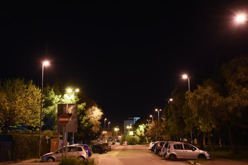 Night Illuminated City by Lamps With Parked Cars