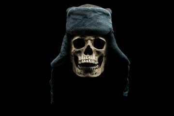 human skull in winter hat isolated on black background. hat with ear flaps. cold weather concept.