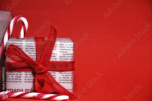 Fotografía Gifts wrapped in old newspaper on red background