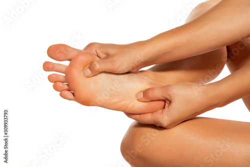 Cuadros en Lienzo woman massaging her painful foot on white background