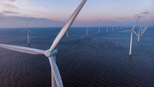 Windmill Park Green Energy During Sunset In The Ocean, Offshore Wind Mill Turbines Netherlands