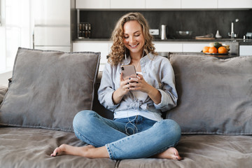 Cheerful young blonde haired woman listening to music