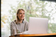 © JustLife - Young woman working in coffee shop. Beautiful female freelancer.