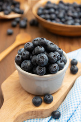Wall Mural - Ripe blueberries in the bowl on the wooden table. Fresh berries for breakfast.