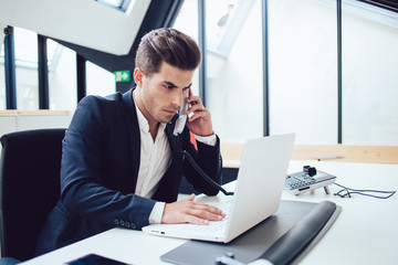 Concentrated male in suit making call