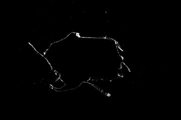 Aufkleber - hole in the glass with cracks isolated on a black background.