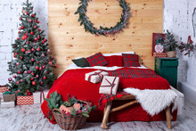 Bedroom Is Decorated For Christmas. Cozy Bright Room: Red Plaid, A Wooden Bed And Basket With Gifts. In Room Is A Christmas Tree Decorated With Toys. Rustic Style. Scandinavian Interior. Hygge Decor