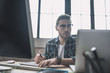 © zinkevych - Young bearded man in eyeglasses drafting schemes