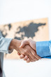 © LIGHTFIELD STUDIOS - partial view of travel agent and client shaking hands in office