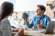 © LIGHTFIELD STUDIOS - cheerful travel agent holding globe while talking to client